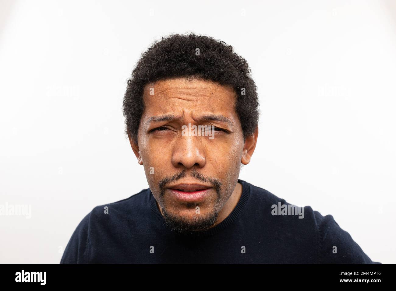 Myopic man without glasses straining his eyes because he can't see well