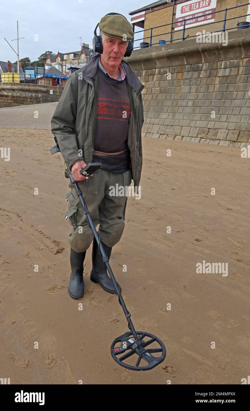 Man using a metal detector, on a beach, near Filey, North Yorkshire, England, UK, YO14 9LA Stock Photo