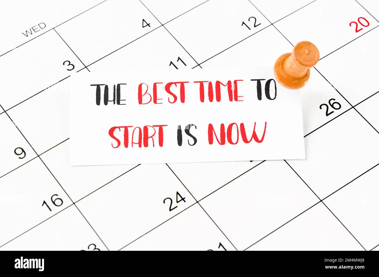 Best time to start is now and wood push pin on calendar page Stock