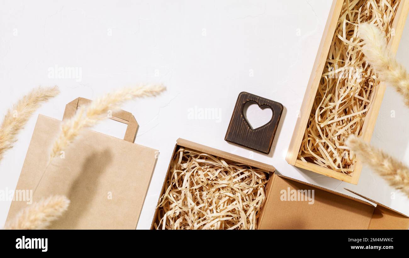 Eco friendly packaging concept. Set of cardboard boxes with shredded paper inside, paper bag for packaging goods from online stores and delivery. Trad Stock Photo