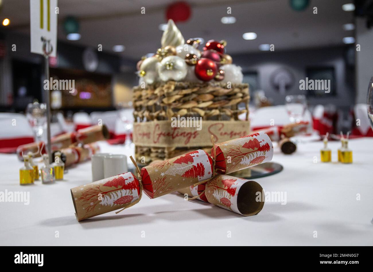 Crackers on decorated table in function room set up for Christmas party event during festive season in UK Stock Photo