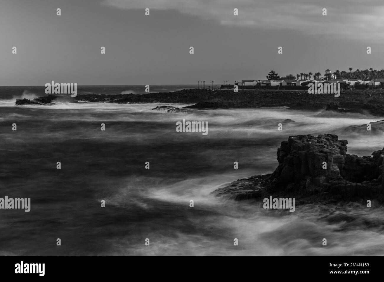A greyscale shot of a rocky coastal landscape in Canary Islands Stock Photo