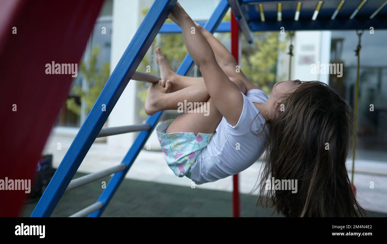 Playful little girl at monkey bar playground upside down Stock Photo ...