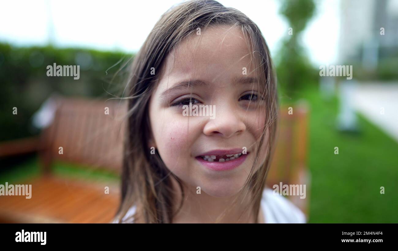 Portrait of little girl standing outside looking at camera child face ...