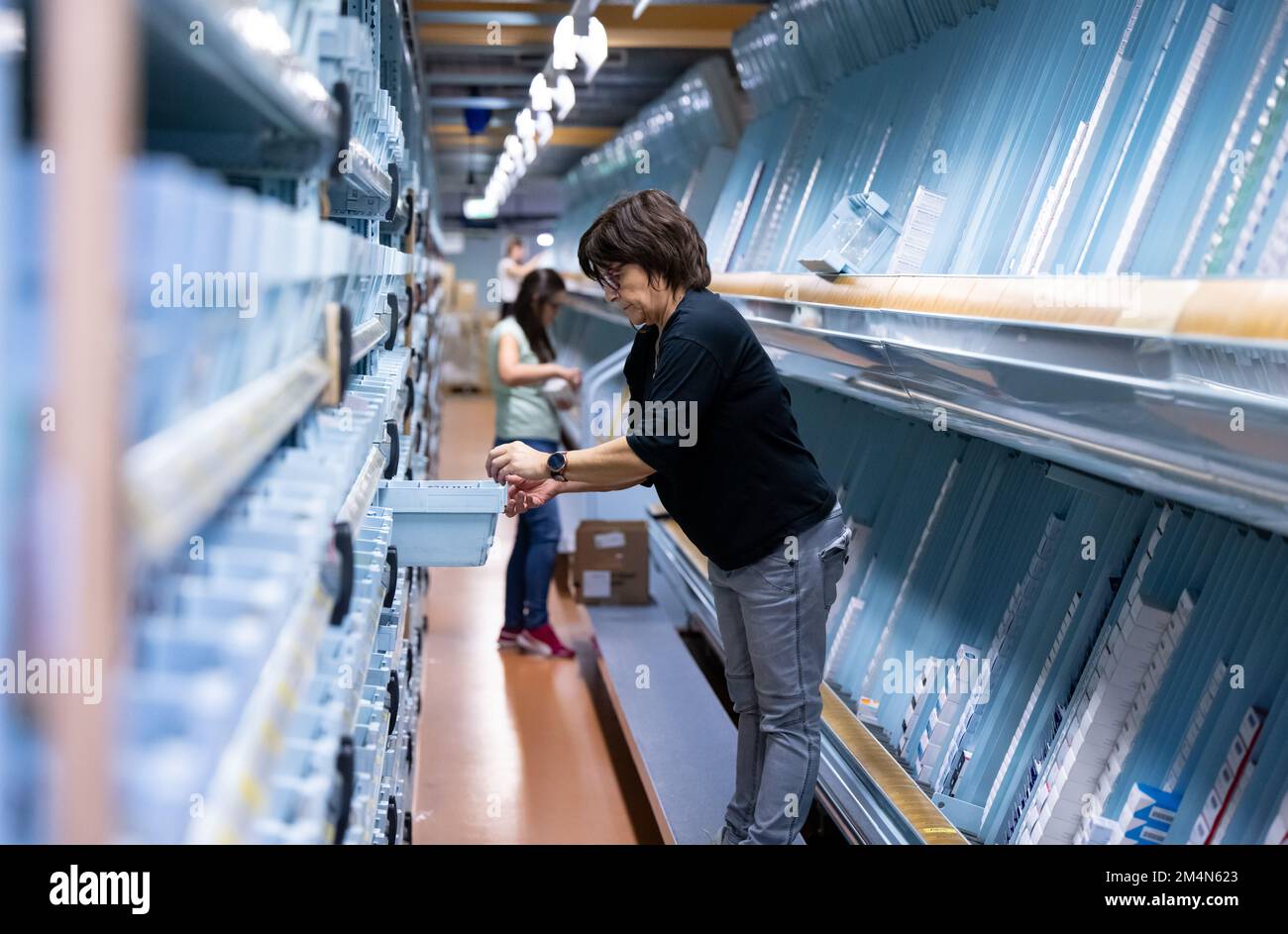Planegg, Germany. 22nd Dec, 2022. An employee fills a system with medicines at the