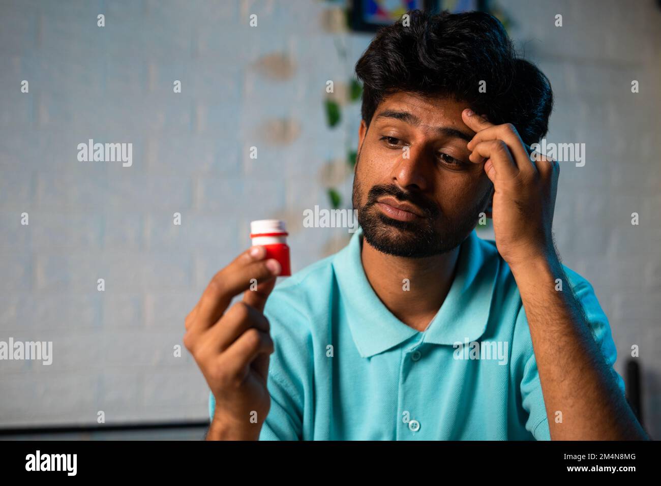 close up shot, young man got relief after applying balm or ointment to forehead due to headache or migraine while sleeping at night - concept of pain Stock Photo