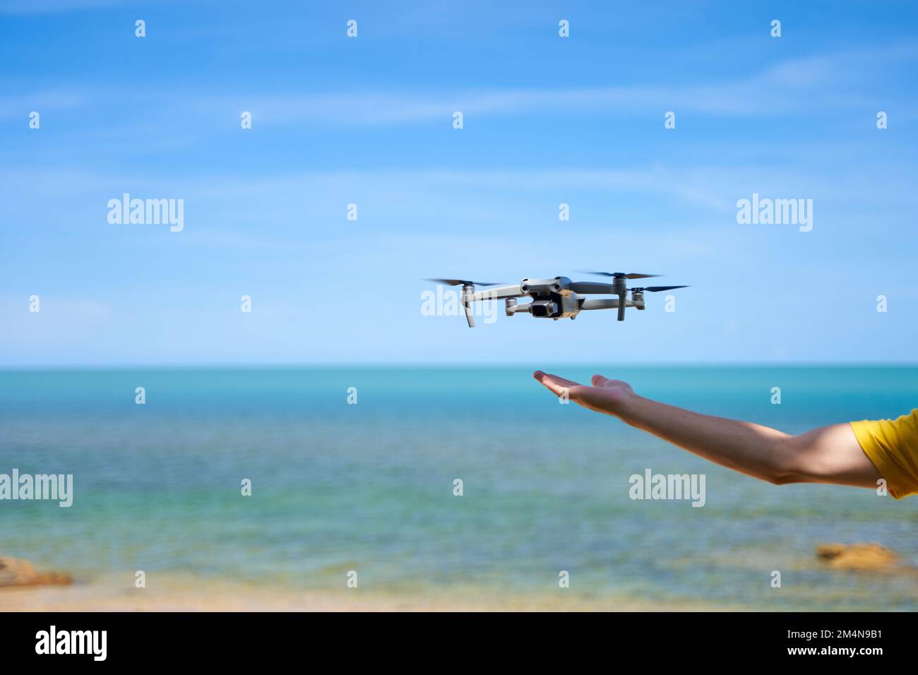 A guy launches from the arm of a prone on the seashore. Stock Photo