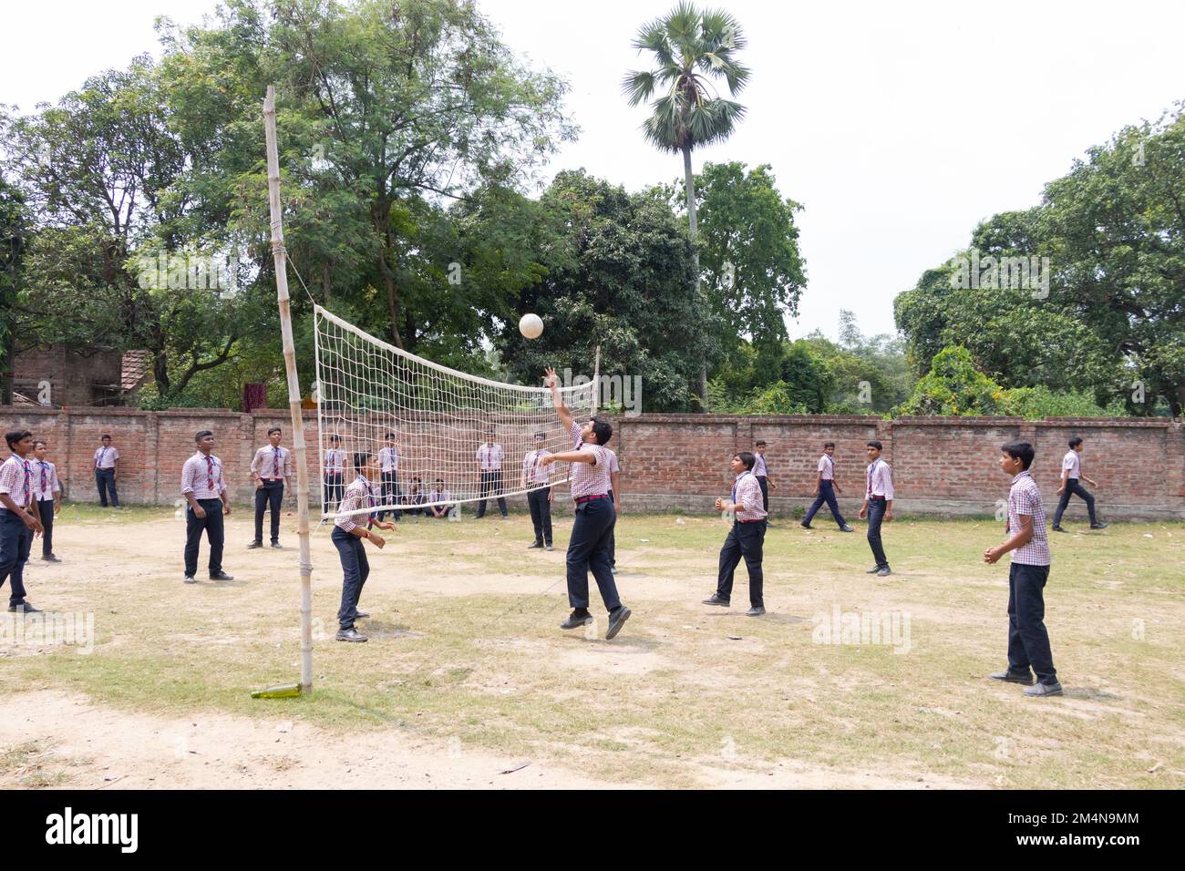 School students playing volleyball in playground stock photos Stock
