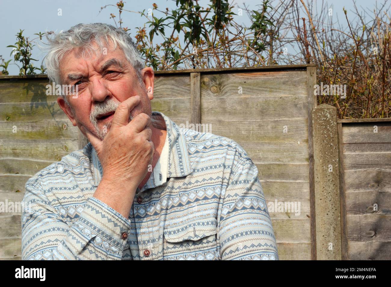 old or senior man looking puzzled and confused. Working out the answer. Stock Photo