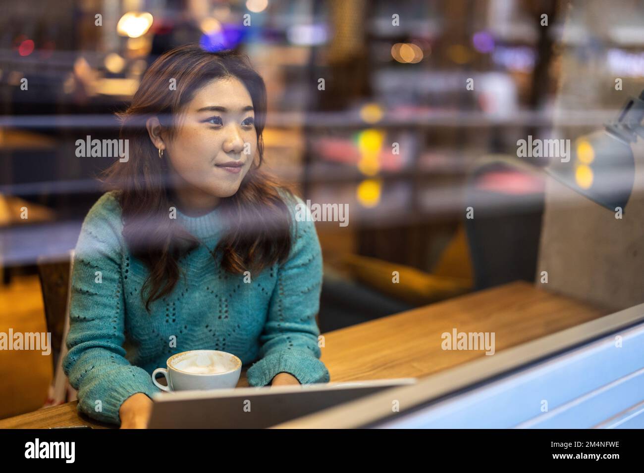 Young woman drinking coffee in cafe Stock Photo