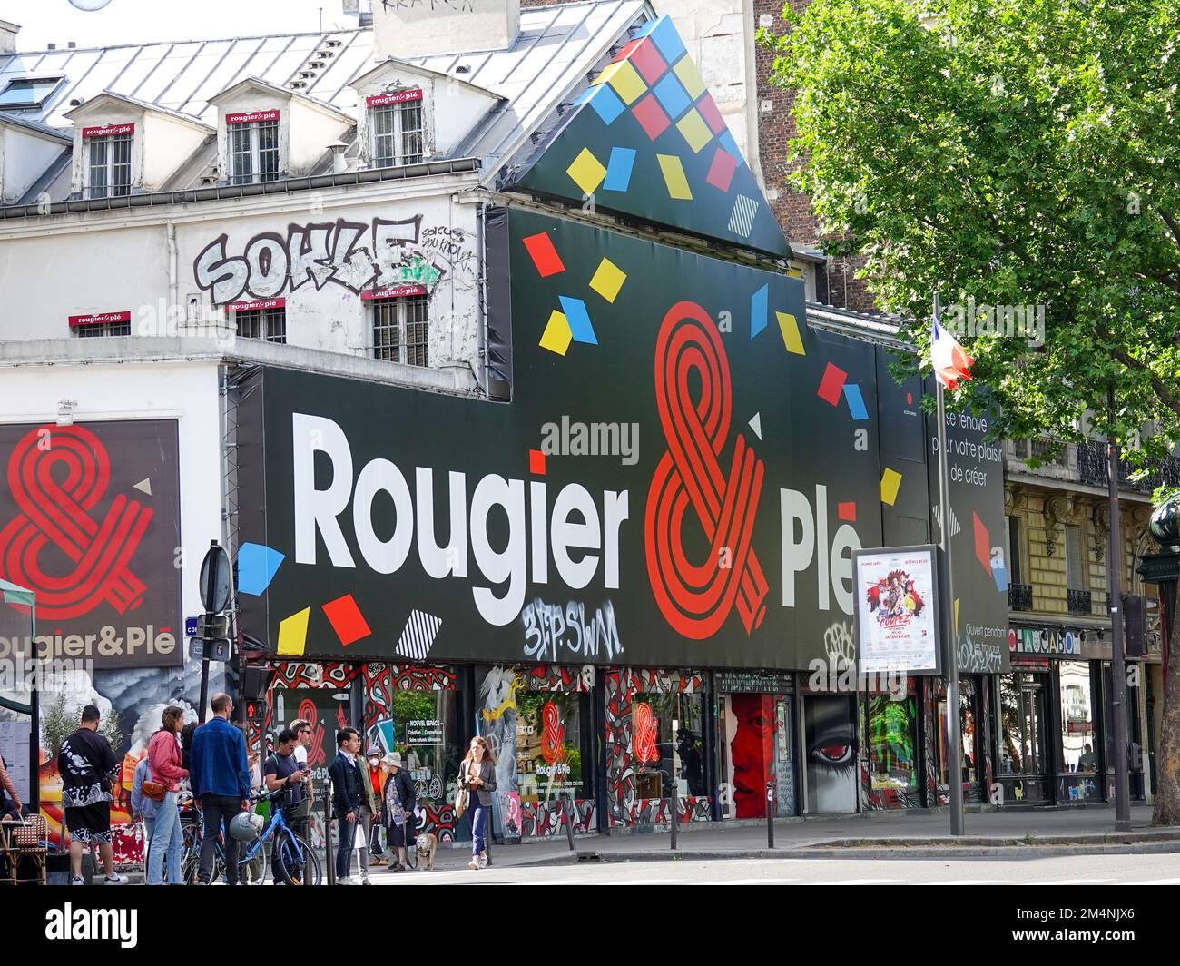 People waiting for the light to change in front of Rougier & Plé, an art supply store with