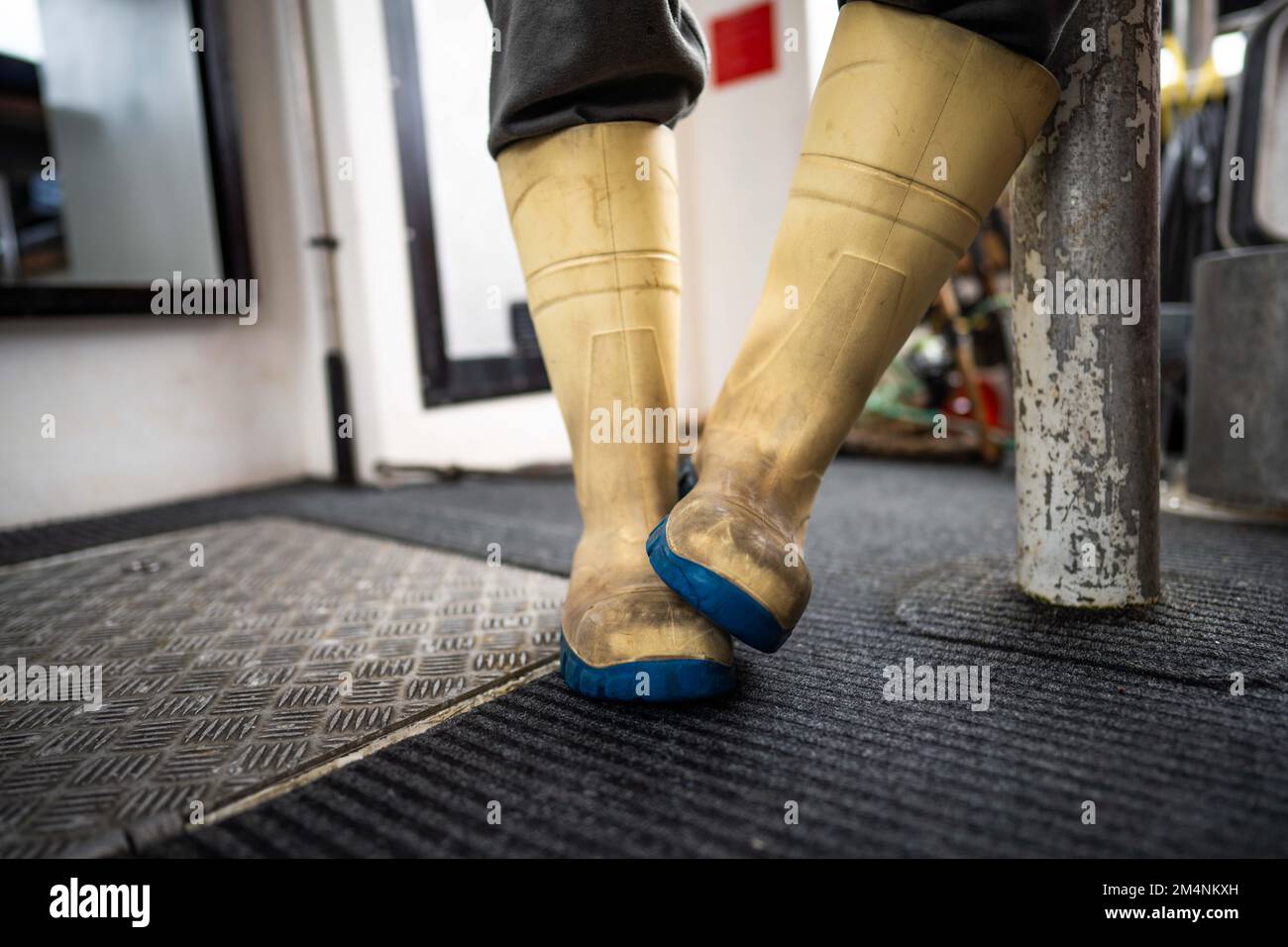 fisherman wearing gumboots, waterproof clothes and gloves on a fishing
