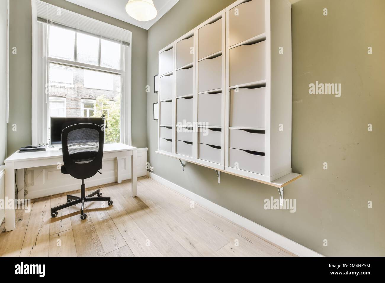 a home office with green walls and white on the wall there is