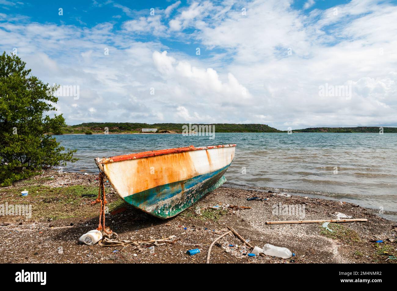 A rusty old boat lies on the beach of St. Joris Bay at the caribbean island Curacao. Stock Photo