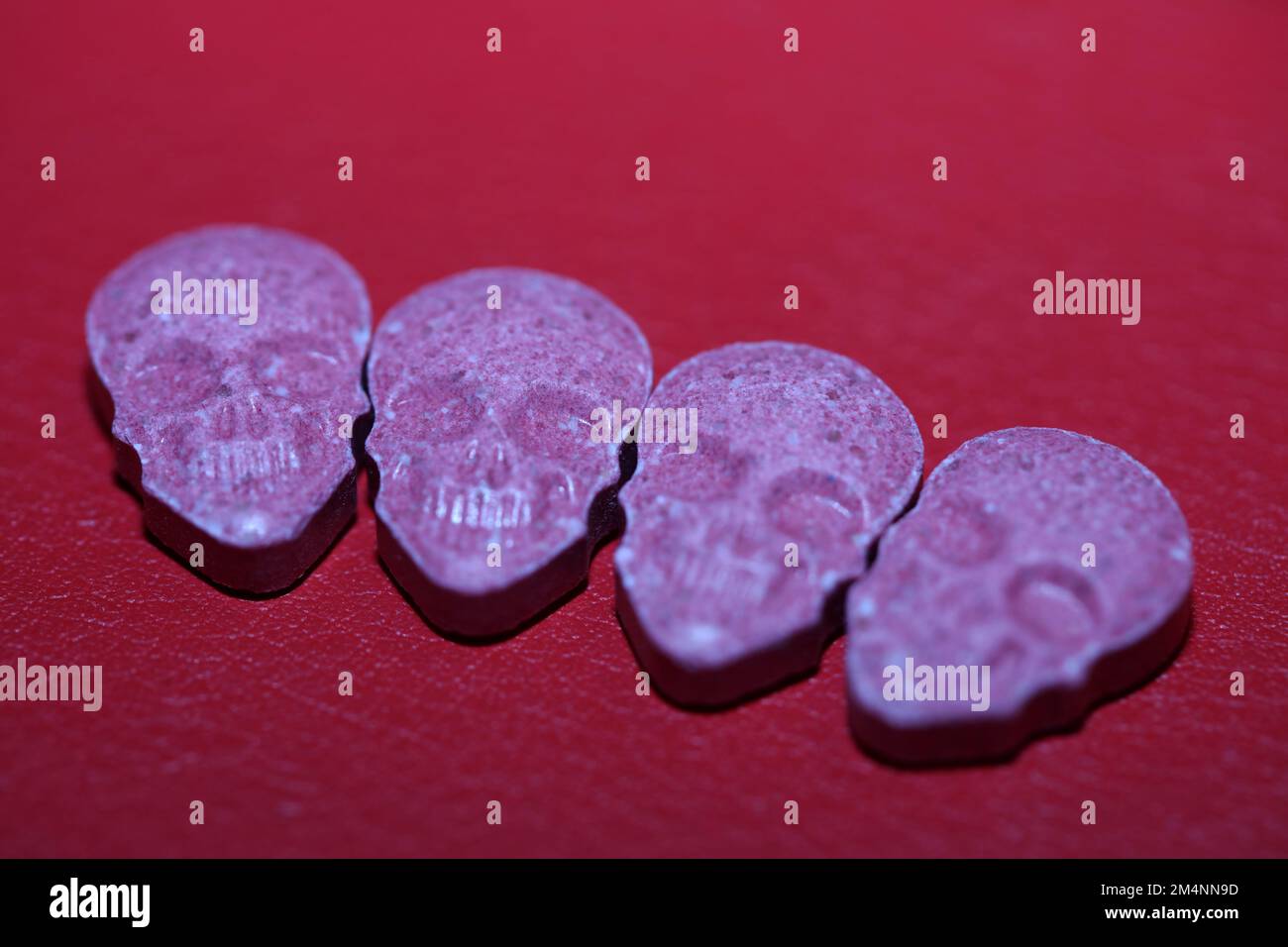 Pink skull ecstasy pill close up background high quality prints purple army dope narcotics substance high dose psychedelic way of life Stock Photo
