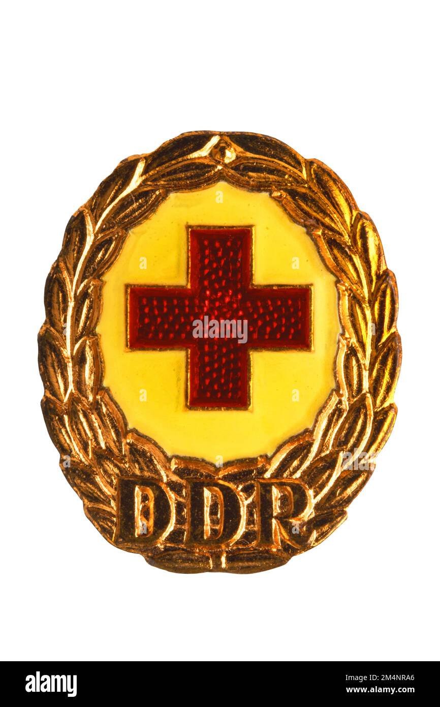 Potsdam, Germany - DEC 12, 2022. Badges, orders and medals from GDR (DDR). Close-up of a National Defence Badge of the German Red Cross in bronze. Cli Stock Photo