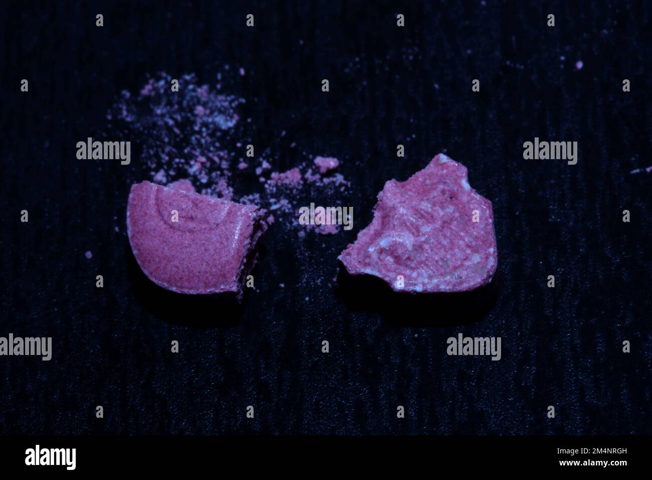 Pink skull ecstasy pill close up background high quality prints purple army dope narcotics substance high dose psychedelic way of life Stock Photo