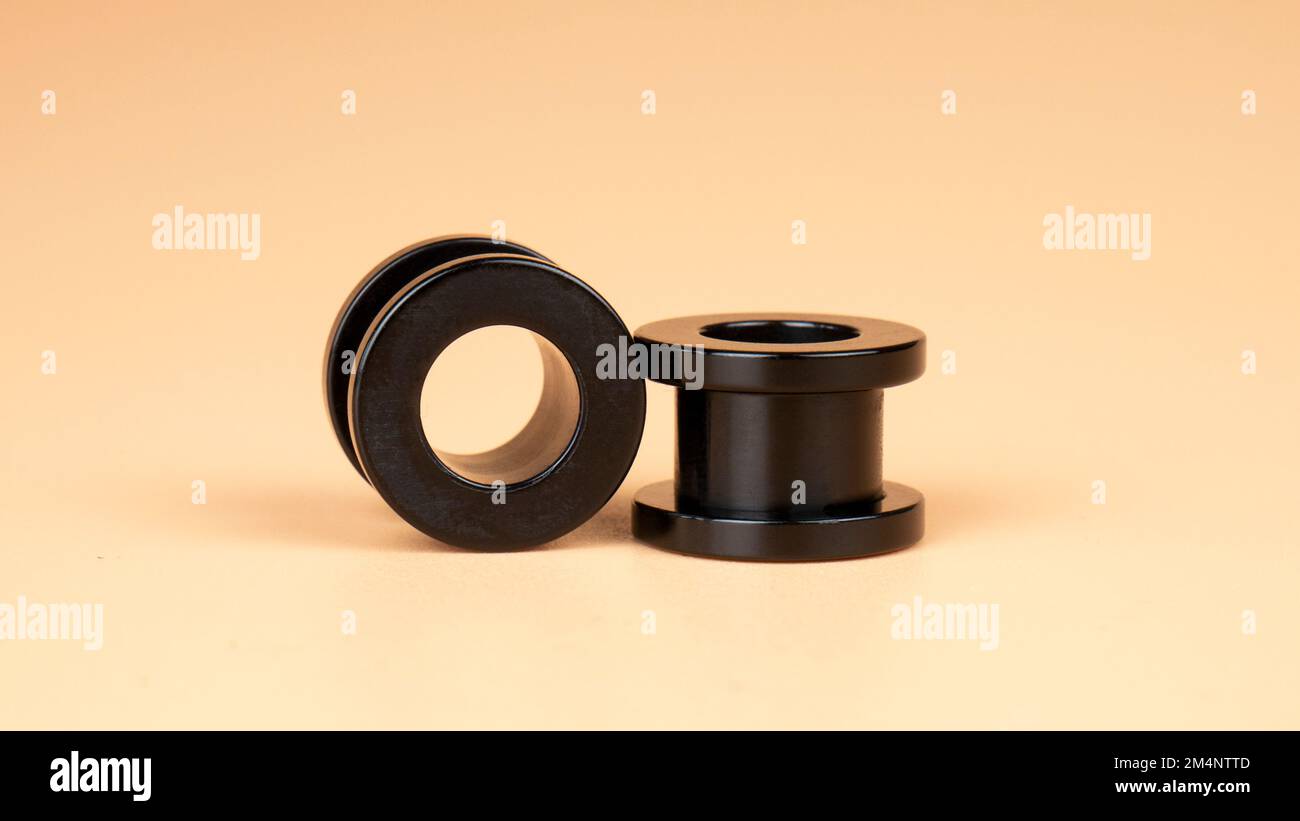 metal black tunnels , ear piercing accessories closeup Stock Photo