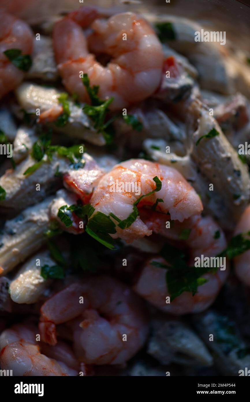 Close-up of shelled prawn and pasta salad lunch snack caught in focused natural light. Stock Photo
