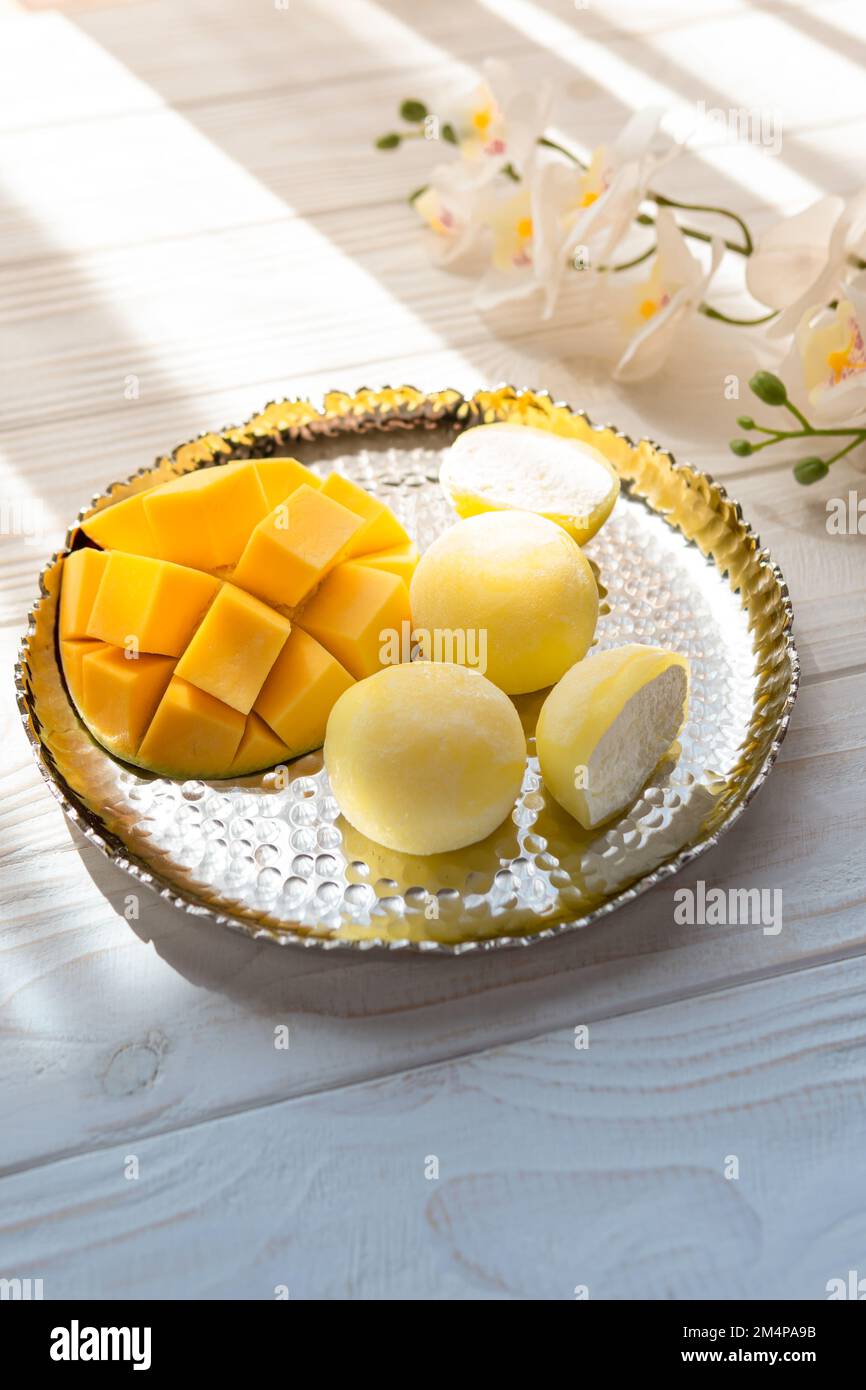 Tasty dessert Mochi with mango fruit on wooden background, close up