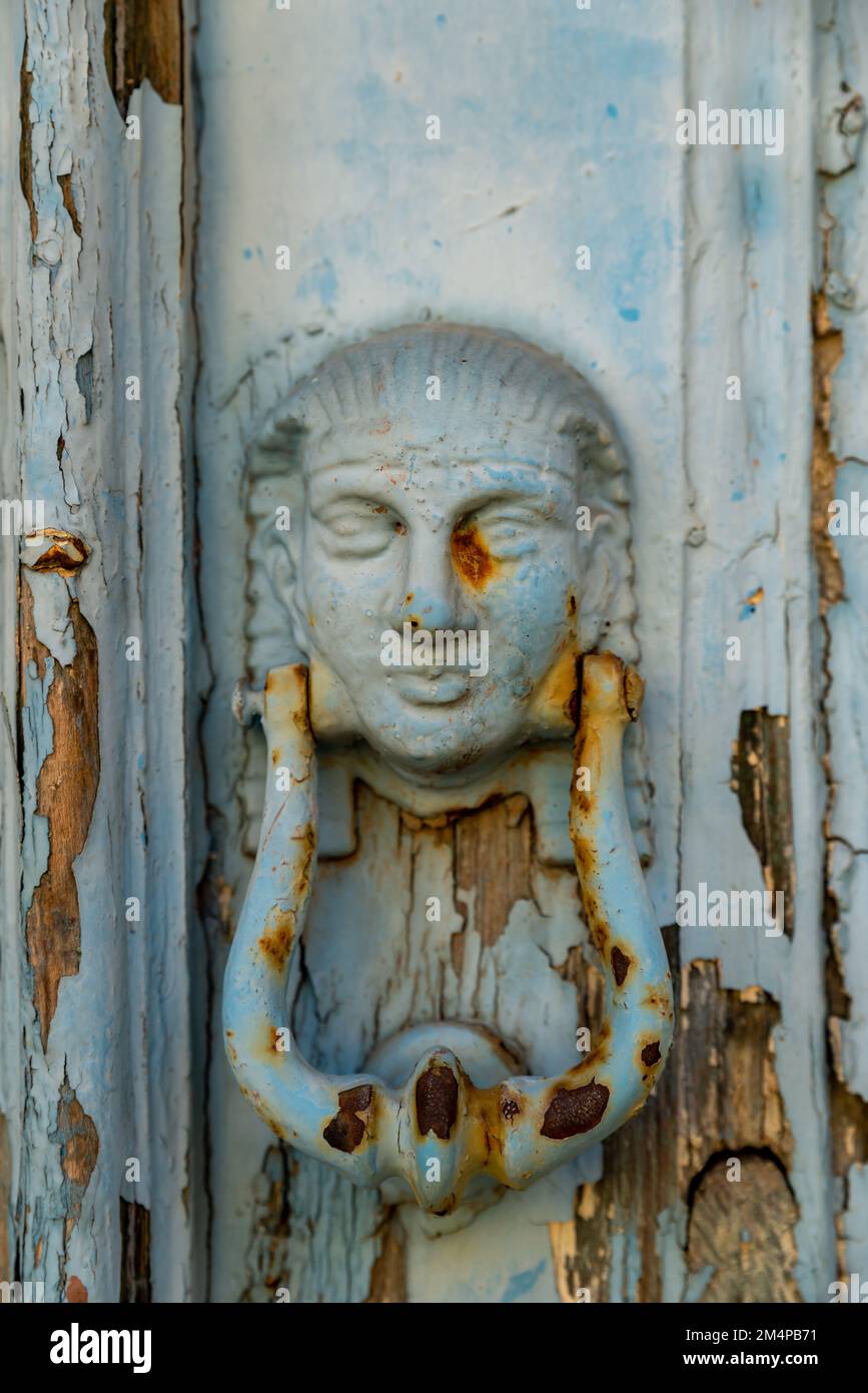 old metal historical doorknob , door with female head figure Stock
