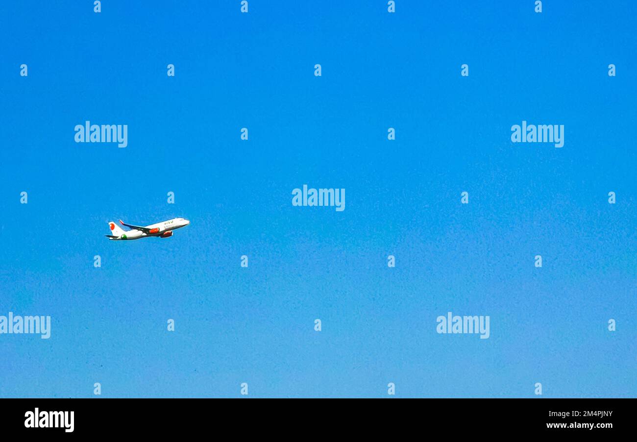 Plane flies thru the clouds with blue sky in Puerto Escondido zicatela Oaxaca Mexico. Stock Photo