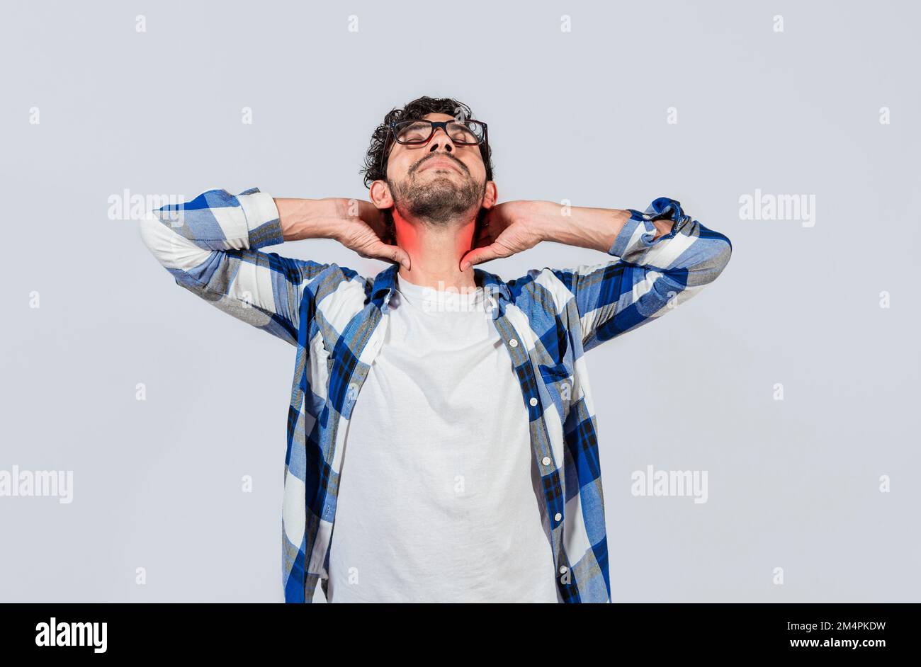 Young man with shoulder and neck problems, Person in pain rubbing his neck isolated, Concept of people with stress and neck pain problems. Tired guy Stock Photo