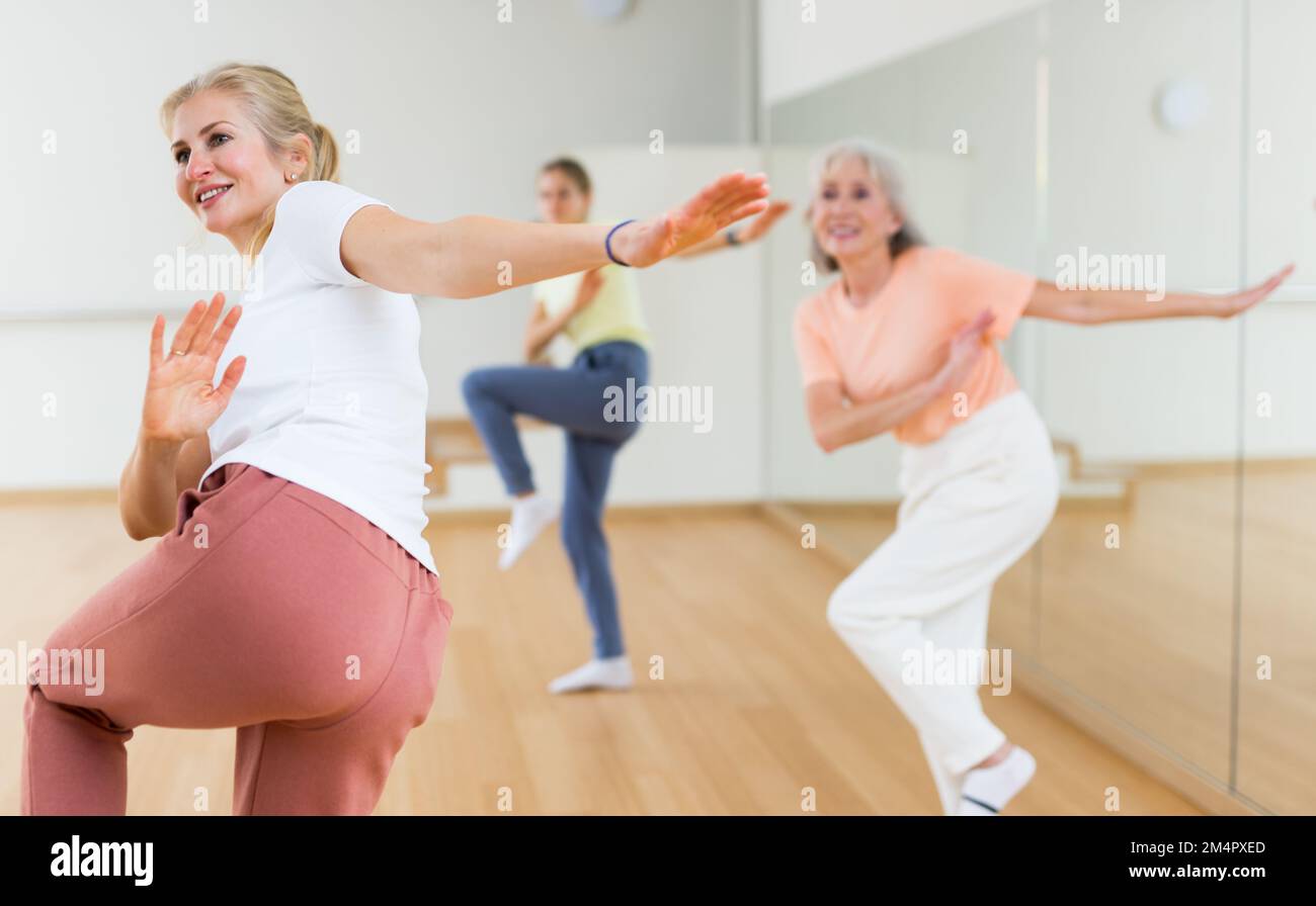 Woman performing aerobic dance during group training Stock Photo