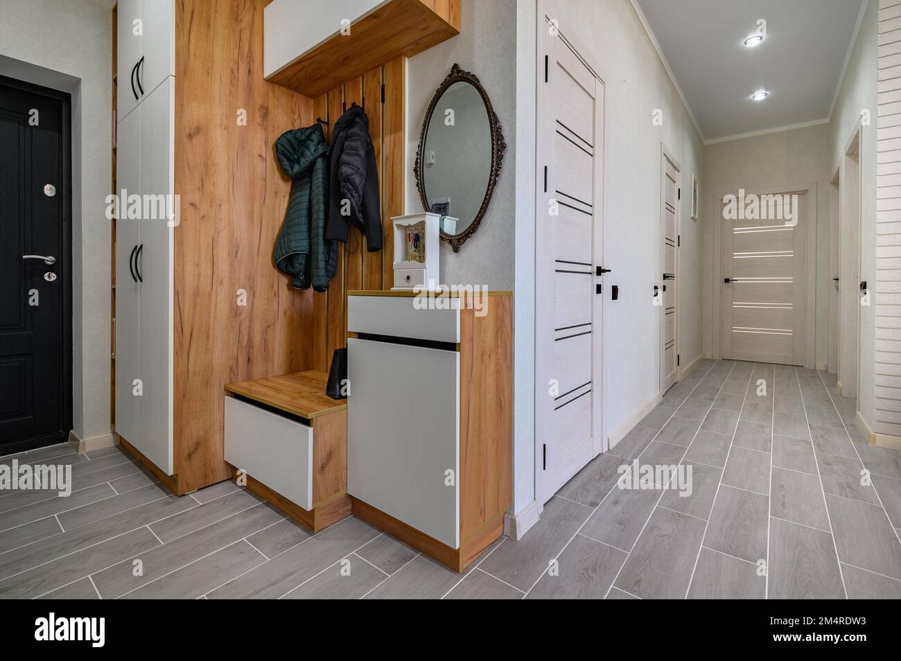 Small entrance hallway interior with shoe storage, hanger stand and mirror Stock Photo