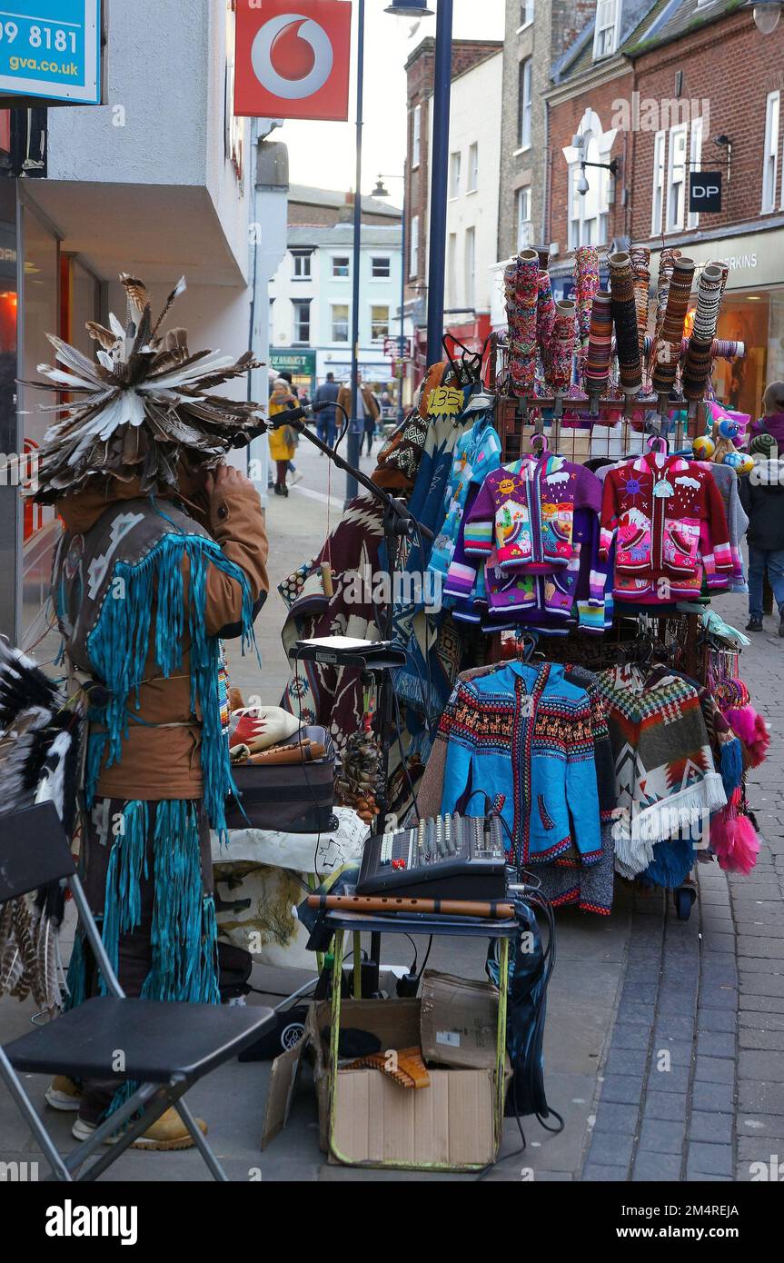 A pop-up store seller in traditional costume selling clothing accessories on the street Stock Photo