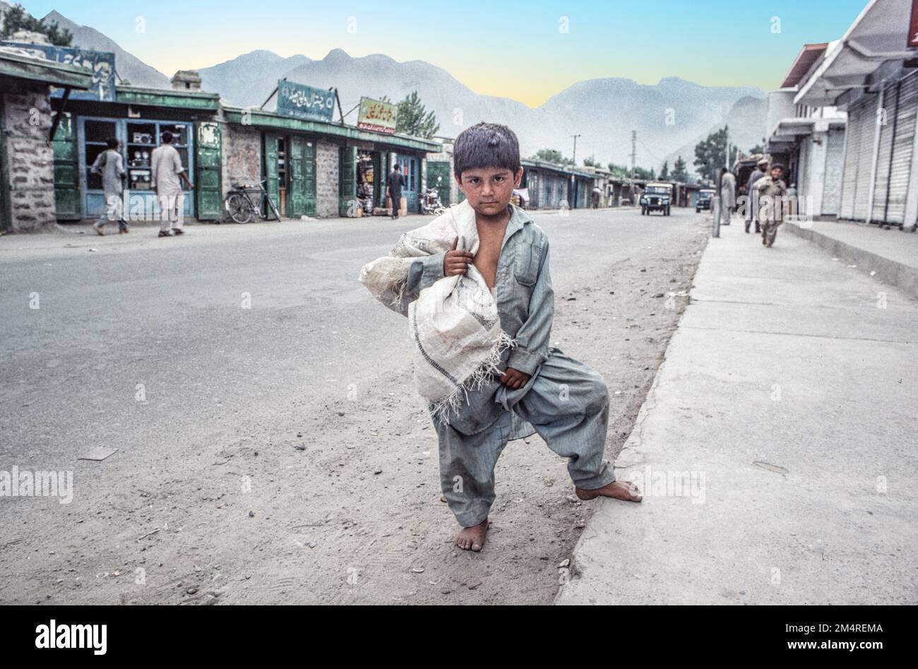 Pakistan, Peshawar - June 30, 1987: boy carrying a sack of rice at the ...