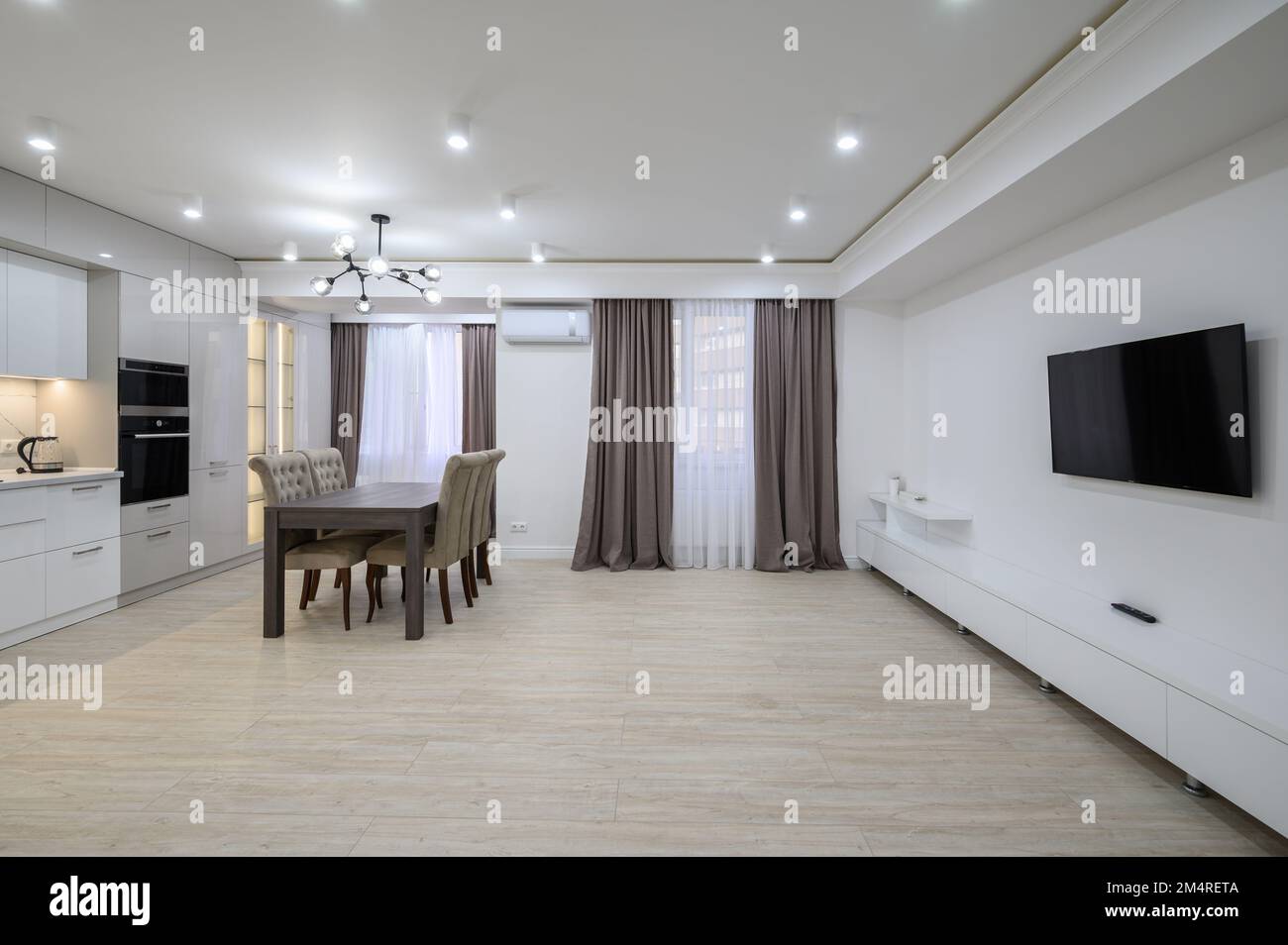 Huge white luxury kitchen in a studio apartment interior Stock Photo