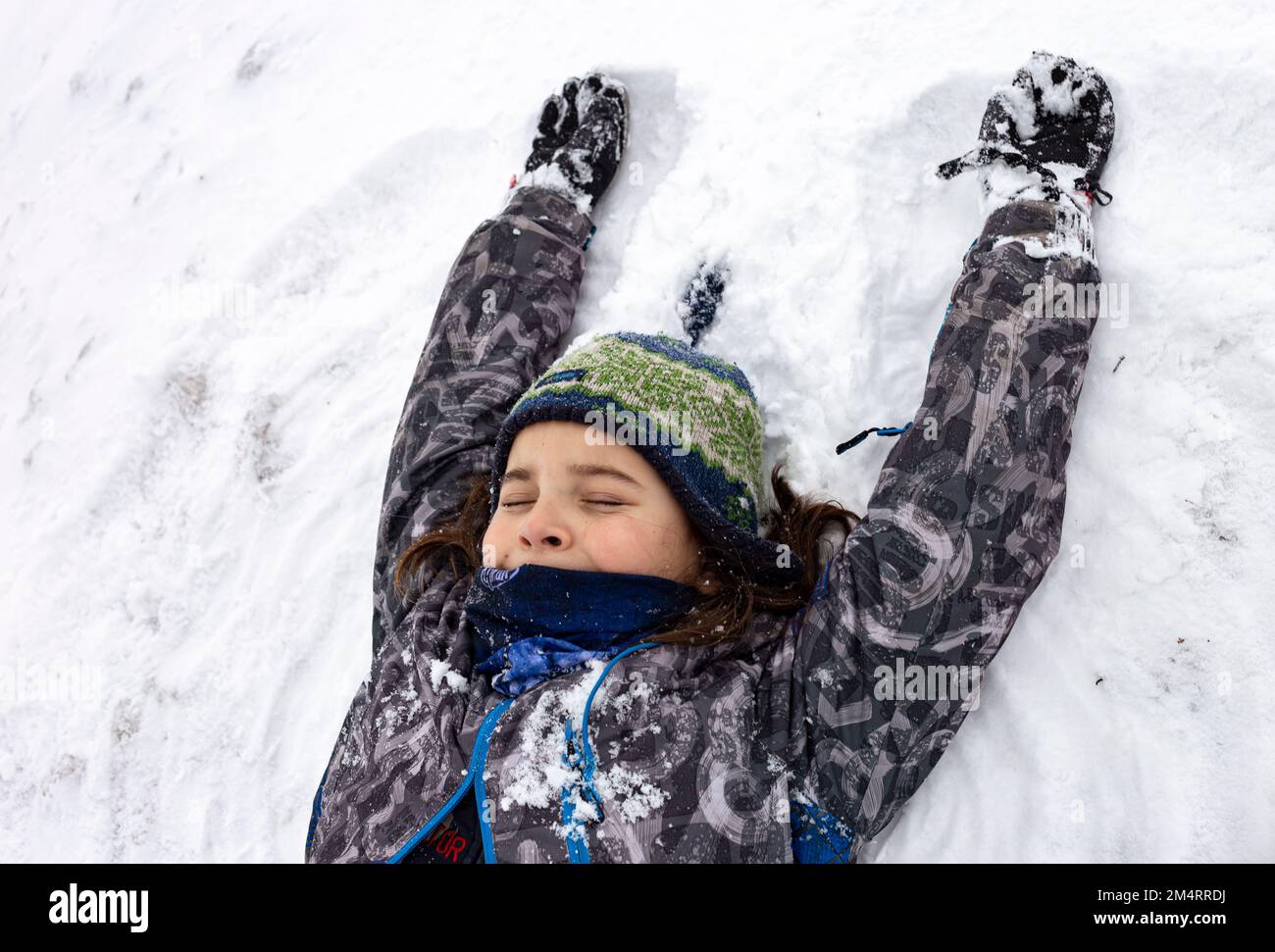 A little boy is playing in the snow Stock Photo