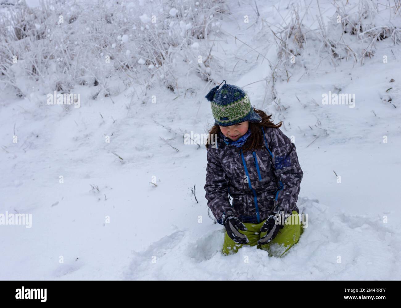 A little boy is playing in the snow Stock Photo