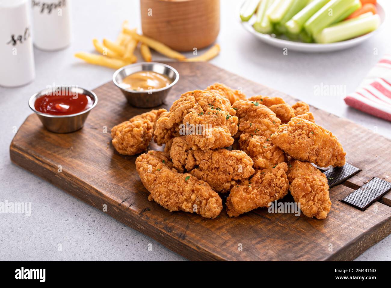 Fried chicken tenders or strips served with ketchup and fries Stock