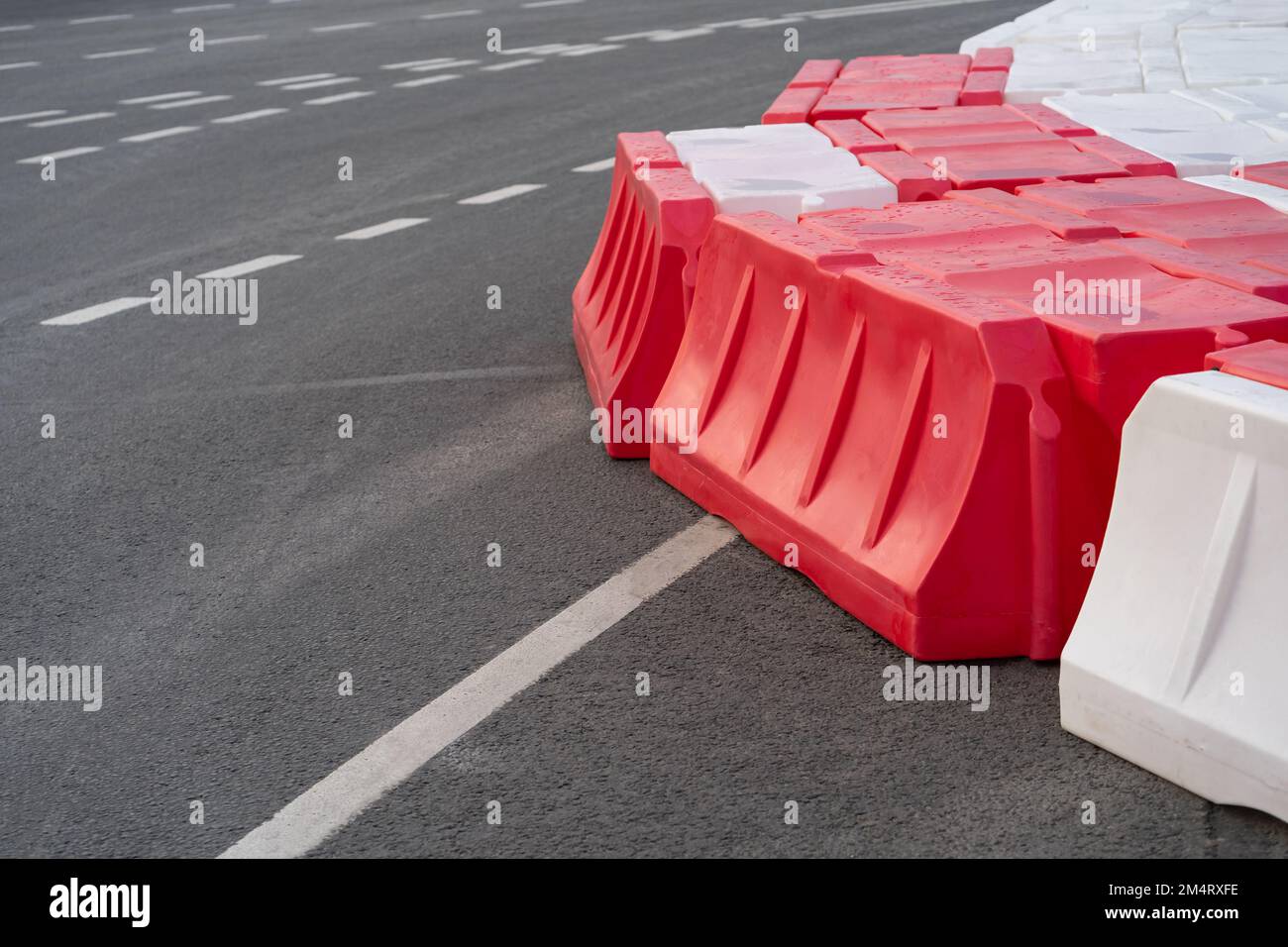 Temporary road barriers installed on asphalt with intermittent markings