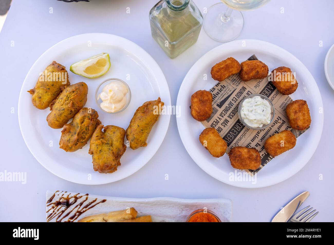 A topview of fried fast food and French toast on a white table in an