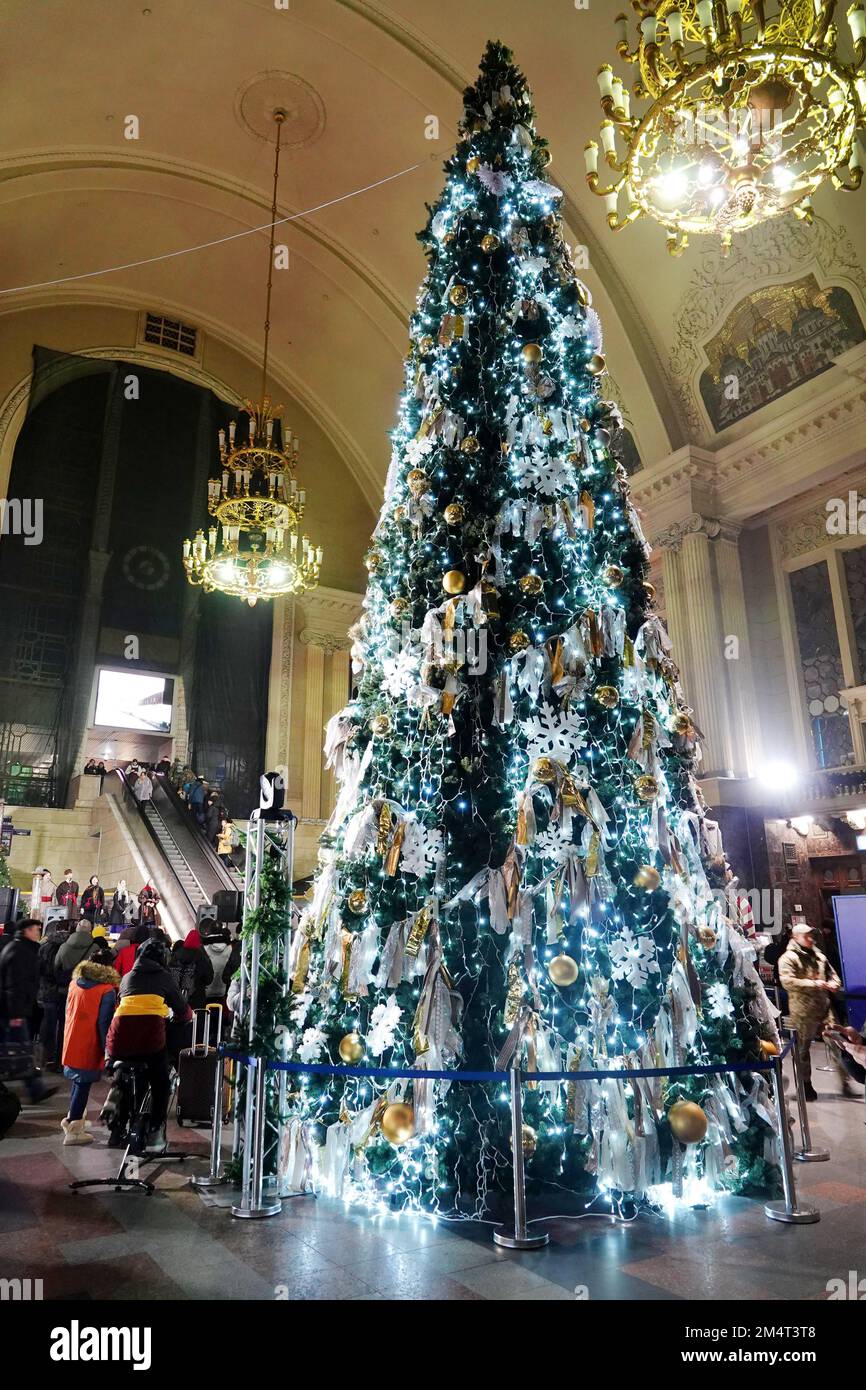 Kiew, Ukraine. 21st Dec, 2022. In the reception hall at the main station, a woman (left) pedals an energy bicycle to light up the decorated tree. (To the KORR report: 'Dark Christmas in Kiev - Putin's war also shifts traditions') Credit: Ulf Mauder/dpa/Alamy Live News Stock Photo