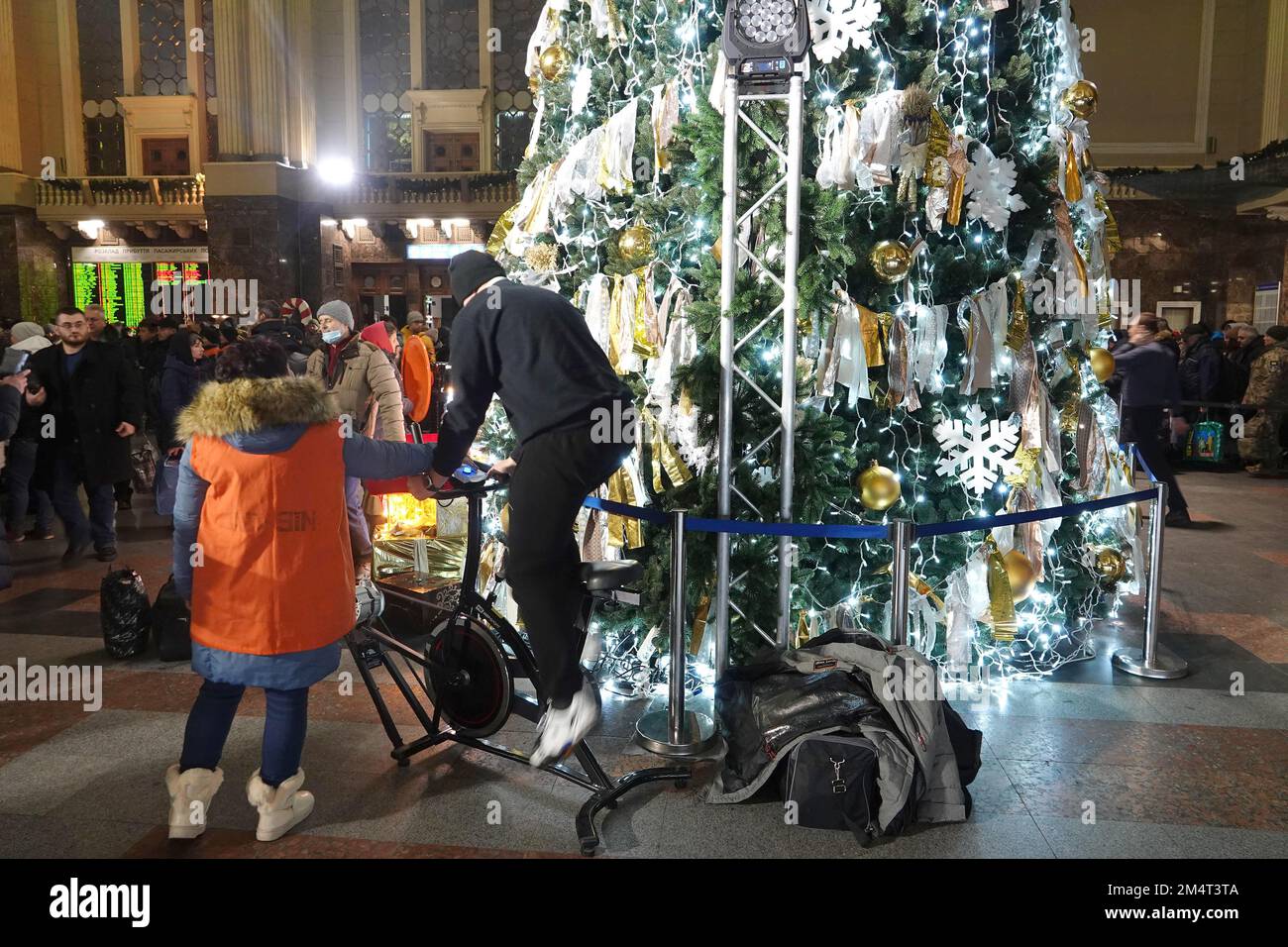 Kiew, Ukraine. 21st Dec, 2022. In the reception hall at the main station, a man on an energy bicycle pedals to light up the decorated tree. (To the KORR report: 'Dark Christmas in Kiev - Putin's war also shifts traditions') Credit: Ulf Mauder/dpa/Alamy Live News Stock Photo