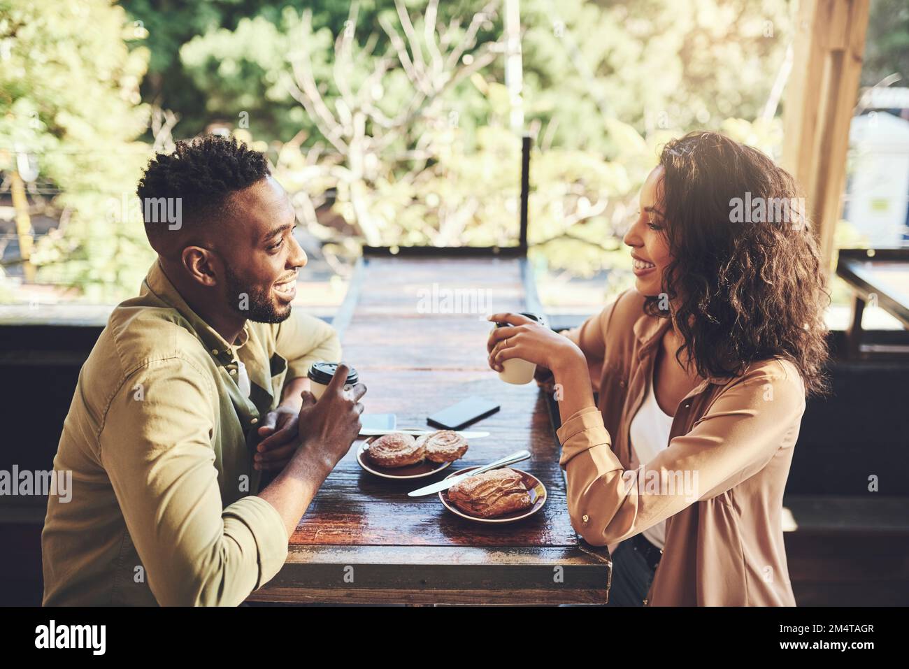 The first of many coffee dates to come. a young couple having pastries