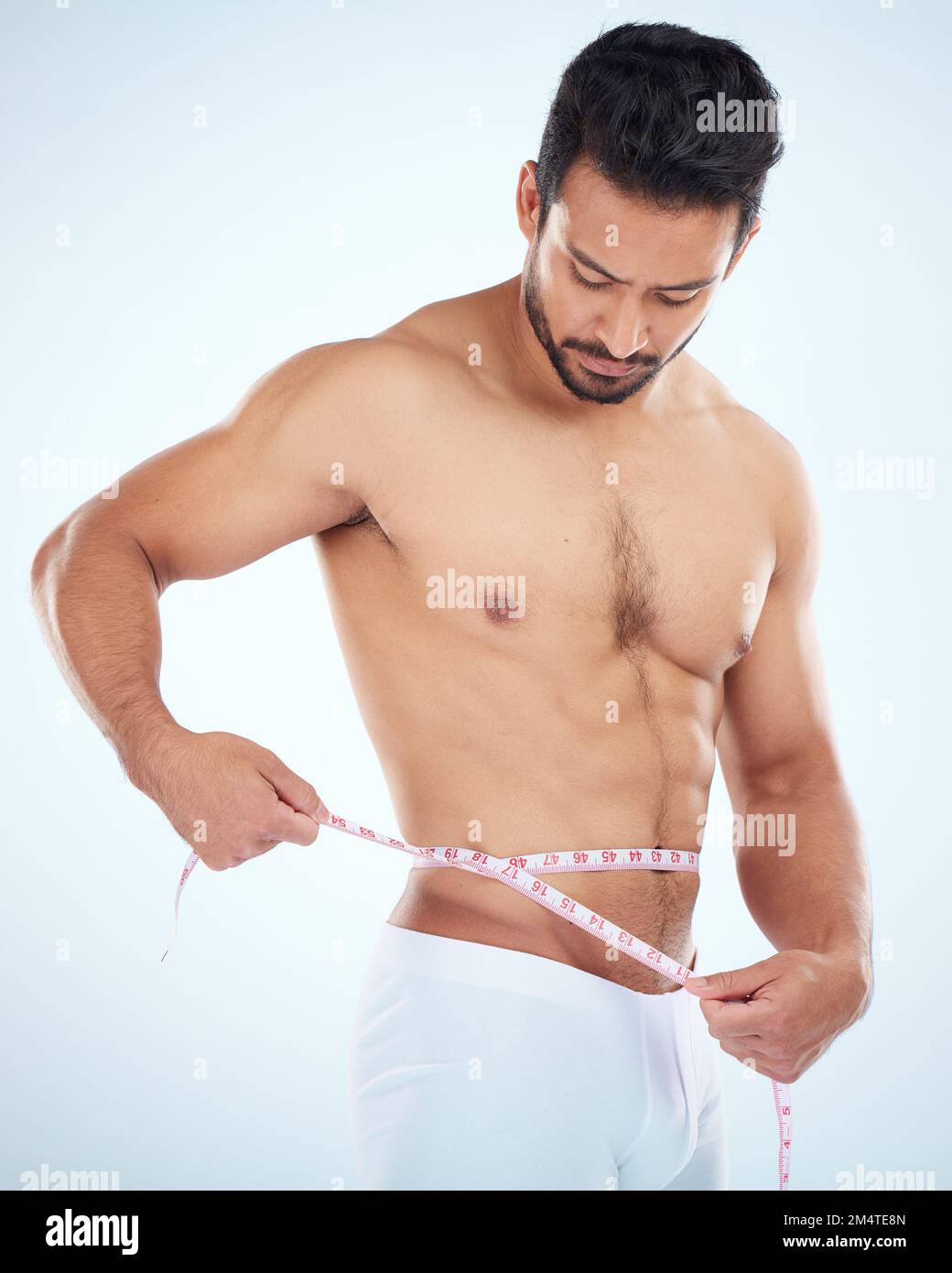 Man, body or measuring tape on waist on studio background for weight loss management, fat control or bmi healthcare wellness. Fitness model, sports Stock Photo