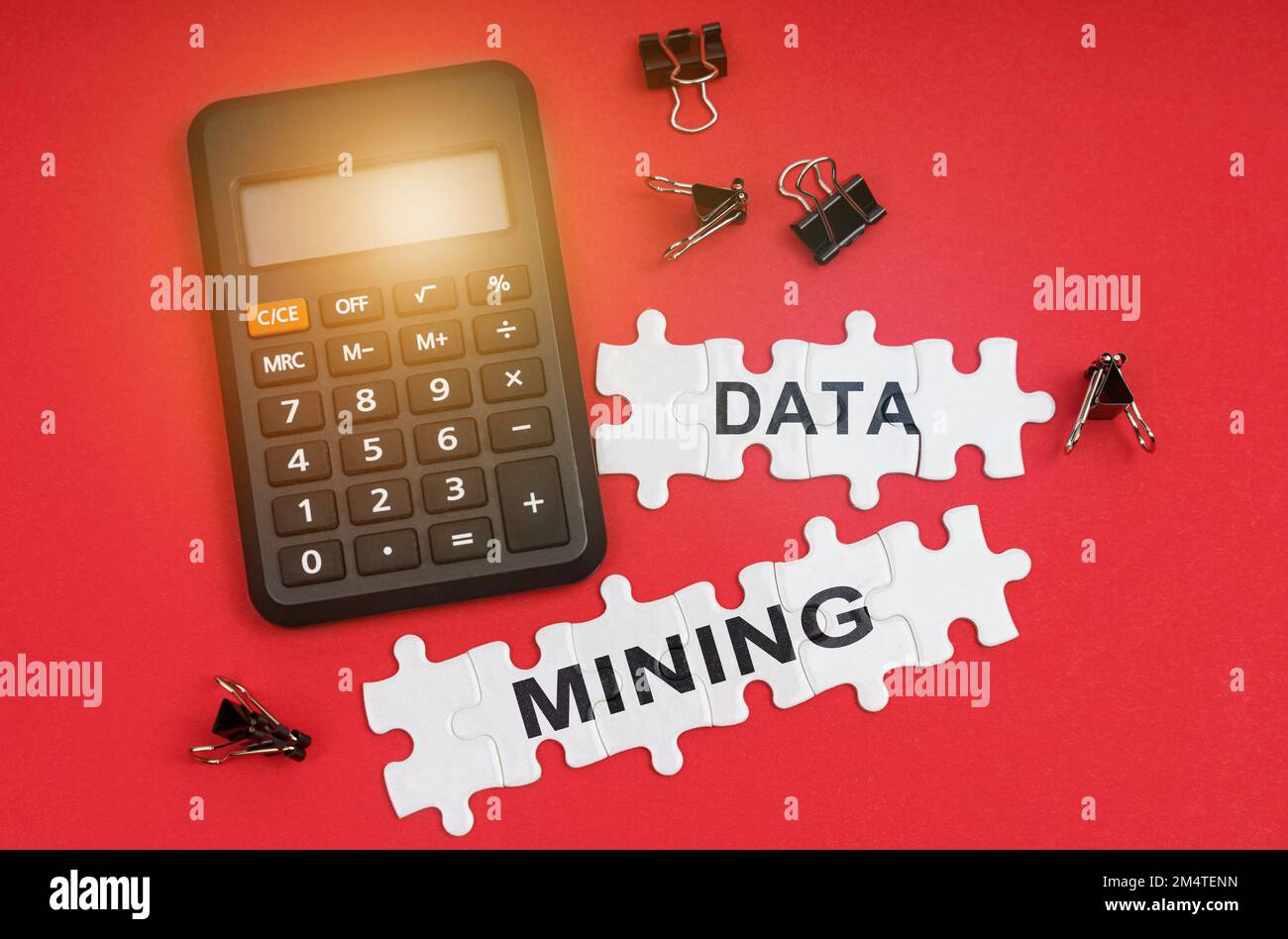 Finance and economy concept. On the red surface are a calculator, clamps and puzzles with the inscription - DATA MINING Stock Photo