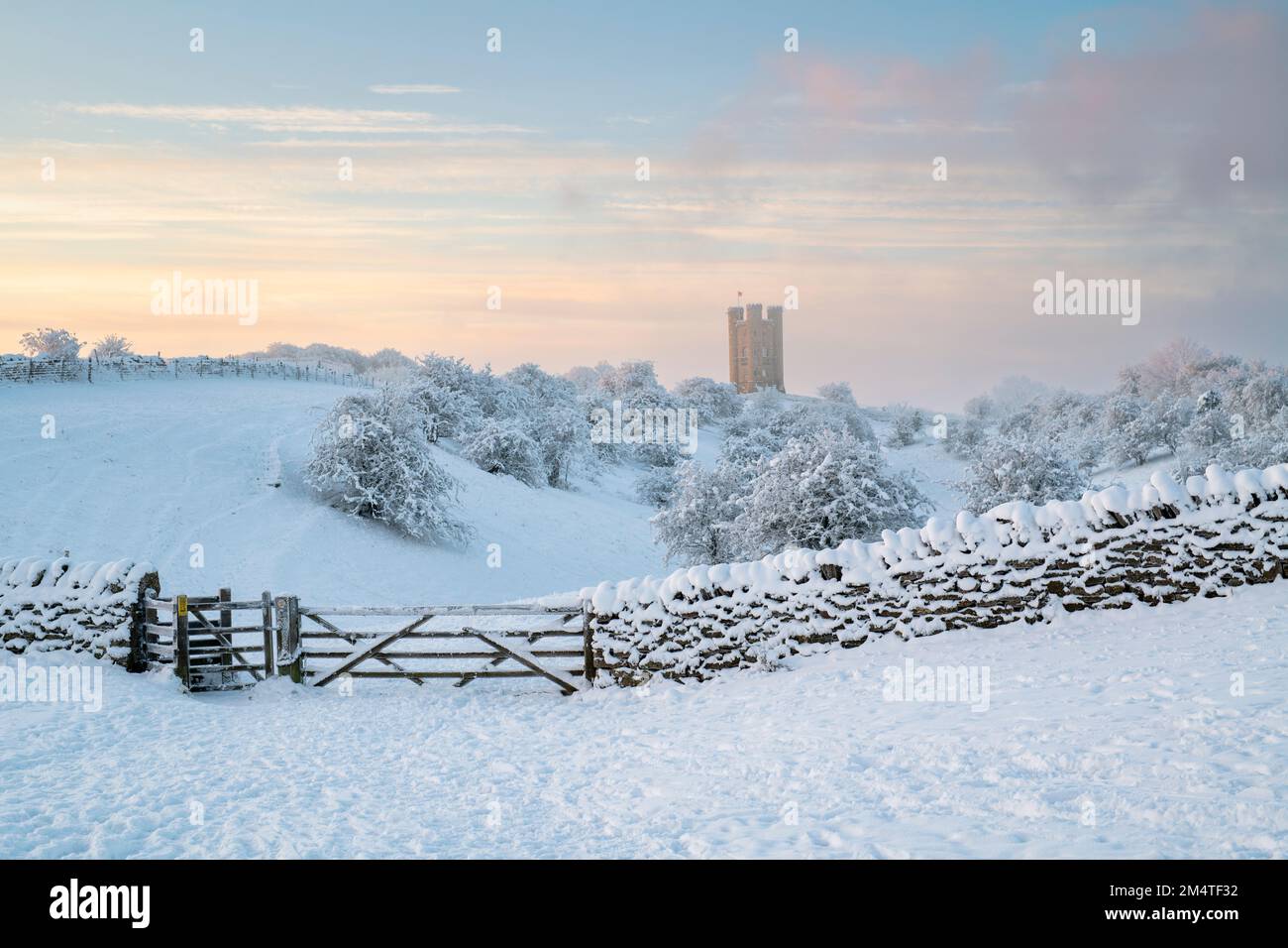Broadway Tower in the early morning winter snow and clearing fog along