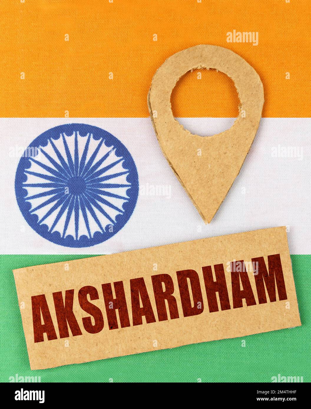 The concept of tourism, vacation and geolocation. On the Indian flag, a geolocation symbol and a sign with the inscription - Akshardham Stock Photo