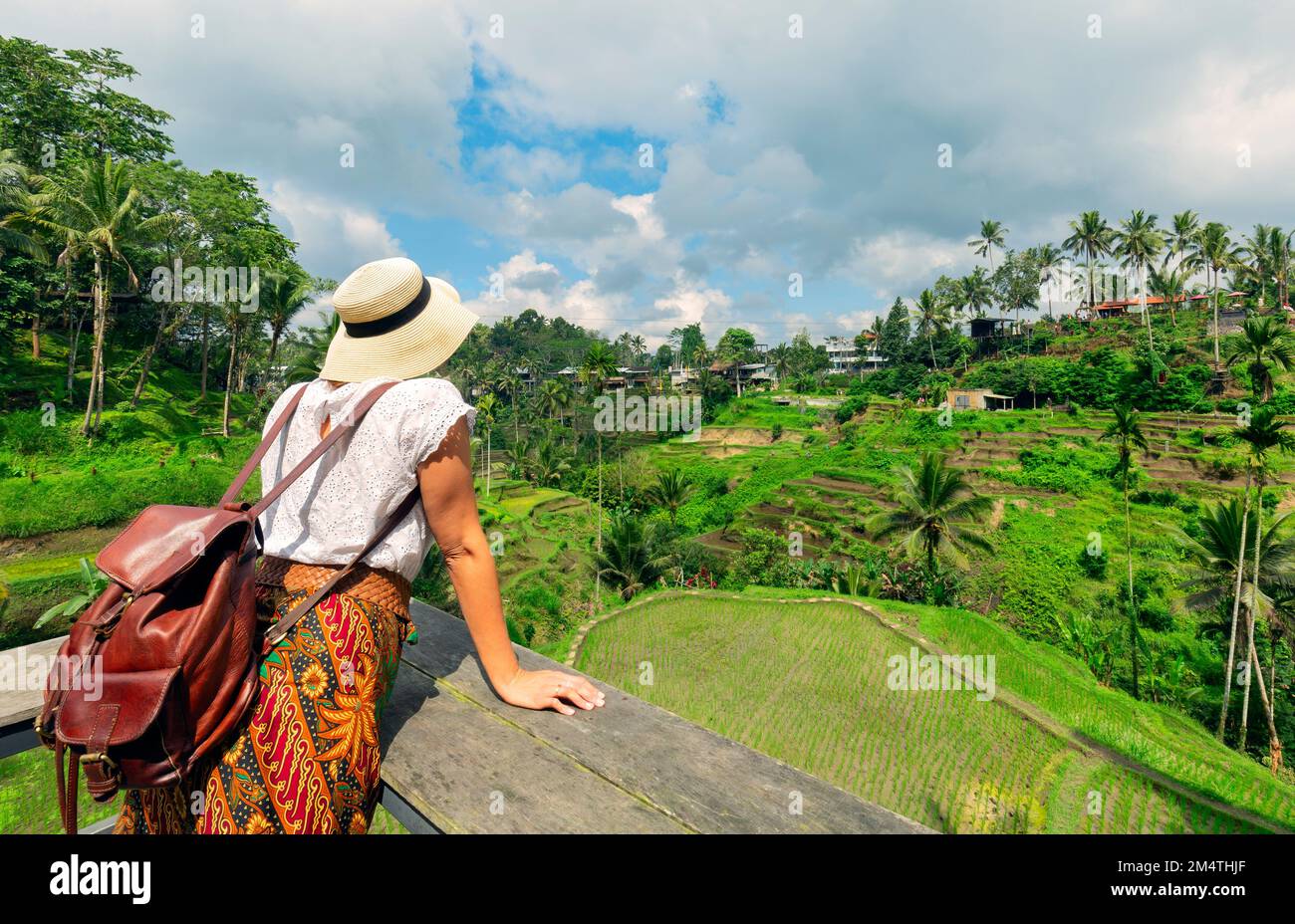 Young girl with hat  looking the ricefields. Rice terraces famous place Tegallalang near Ubud. The island Bali in indonesia in southeastasia. Stock Photo