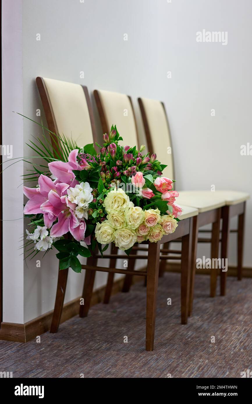 Big colourful flower bouquet on a white chair. Wedding day. Stock Photo