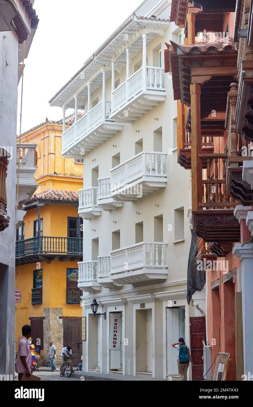 A vertical footage of a street in Cartagena with colorful buildings and people walking around in Colombia Stock Photo