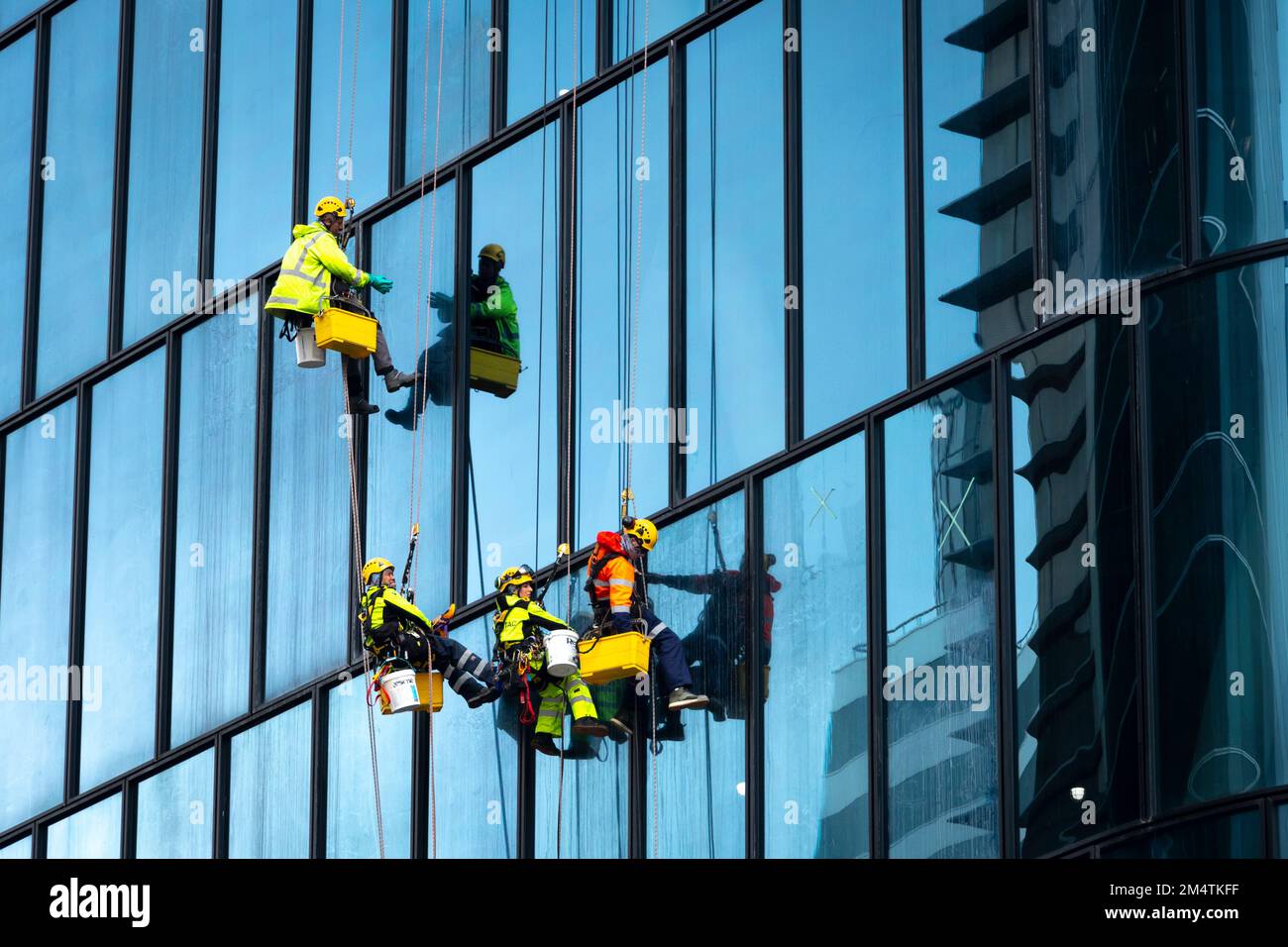 Workers cleaning windows on high office building, Wellington, North Island, New Zealand Stock