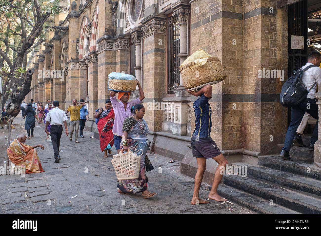 Porters with baskets of fish on their heads, at Chhatrapati Shivaji Maharaj Terminus (CMST), in Mumbai, India, to forward the baskets by train Stock Photo