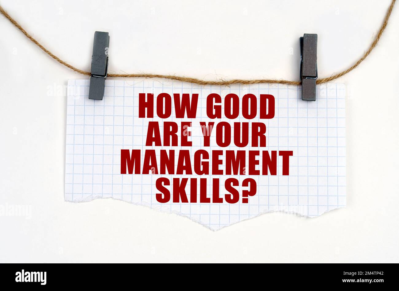 Business concept. A sheet of paper with the inscription is attached to the rope with clothespins - HOW GOOD ARE YOUR MANAGEMENT SKILLS Stock Photo